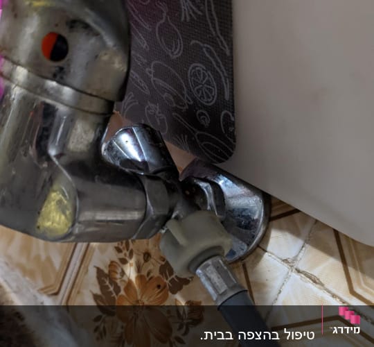 ברז מתכת מחובר לצינור גומי אפור